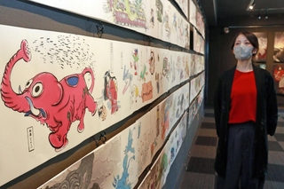 鮮やかな色使いが目を引く展示作品と、制作したさきゅうさん＝神戸市中央区北野町２、うろこの家