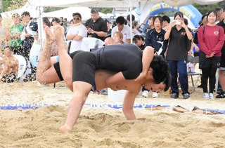 砂をはね上げながら組み合う出場者＝須磨海岸