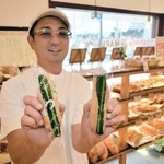名物の「漬物ドック」（左）と「やみつきドック」を手にする末武達三さん＝神戸市垂水区神田町
