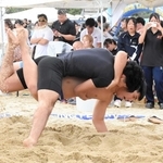 砂をはね上げながら組み合う出場者＝須磨海岸