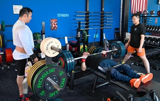 「ＲＥＣＯＮ」でトレーニングする光瀬智洋さん（中央）と、補助する田中翔悟さん（左）＝８月、姫路市