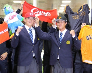 広島から２位指名を受けガッツポーズする亜大の斉藤汰直投手（左）と巨人３位の山城京平投手＝２３日、東京都武蔵野市