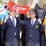 広島から２位指名を受けガッツポーズする亜大の斉藤汰直投手（左）と巨人３位の山城京平投手＝２３日、東京都武蔵野市