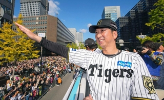 セ・リーグ優勝記念パレードで、バスの上からファンに手を振る阪神・藤川監督＝２２日午前、大阪・御堂筋（代表撮影）