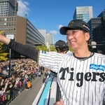 セ・リーグ優勝記念パレードで、バスの上からファンに手を振る阪神・藤川監督＝２２日午前、大阪・御堂筋（代表撮影）