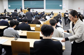 問題用紙の配布を待つ受験生ら＝１７日午前、神戸市東灘区岡本８、甲南大