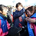 競り負けて２位でゴールし、涙するアンカー永長里緒（手前右から２人目）に声をかける田中希実（左端）＝撮影・丸山桃奈