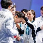 団体女子フリーの得点を確認し、感極まった坂本花織をなでる三浦璃来（右から２人目）＝８日、イタリア・ミラノ（共同）