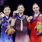 　フィギュアスケート世界選手権の女子表彰式でメダルを掲げる、優勝した坂本花織（中央）と２位の千葉百音（左）。坂本は現役最後の試合を日本勢最多となる４度目の頂点で締めくくった＝27日、チェコ・プラハ（共同）