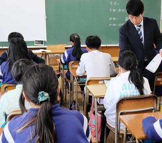 答案用紙の配布を待つ児童たち＝２３日午前、神戸市内