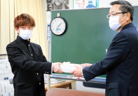 兵庫県教育委員会の西田健次郎教育次長（右）に約１万６千人分の署名を手渡す男子高校生＝兵庫県庁