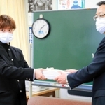 兵庫県教育委員会の西田健次郎教育次長（右）に約１万６千人分の署名を手渡す男子高校生＝兵庫県庁