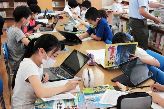 前期課程の図書室で調べ学習に取り組む５年生の児童ら＝豊富小中学校