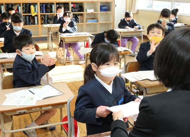 通知表を受け取る児童＝２３日午前、兵庫県稲美町森安
