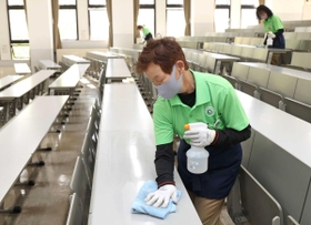 大学入試共通テストを翌日に控え、机や椅子をアルコール消毒する作業員＝１５日午後、西宮市上ケ原一番町（撮影・辰巳直之）