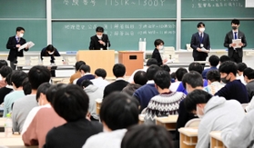 マスクを着用して注意事項を説明する試験官たち＝１６日午前、神戸市東灘区岡本８、甲南大岡本キャンパス（撮影・中西幸大）