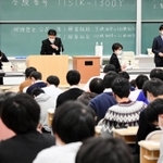 マスクを着用して注意事項を説明する試験官たち＝１６日午前、神戸市東灘区岡本８、甲南大岡本キャンパス（撮影・中西幸大）