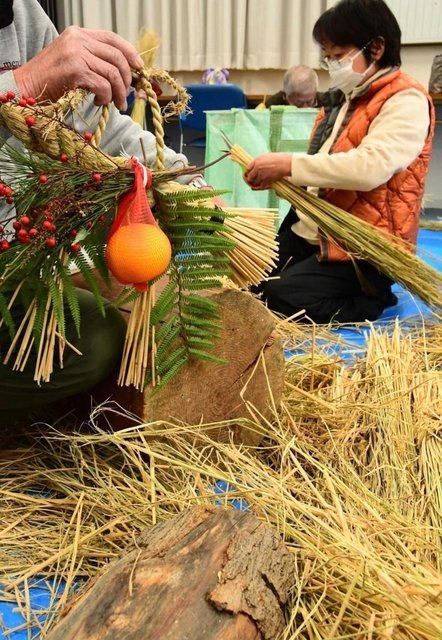 見本のしめ縄（左）を参考に制作する参加者＝東條町公民館