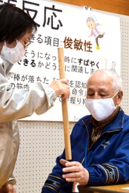 棒をつかむ速さで俊敏性を測る検査＝三木南交流センター