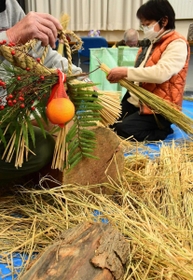 見本のしめ縄（左）を参考に制作する参加者＝東條町公民館