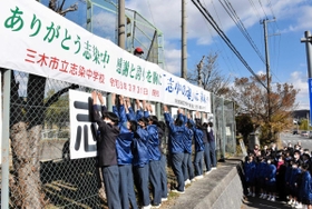 協力して横断幕を掲げる生徒ら＝志染中学校
