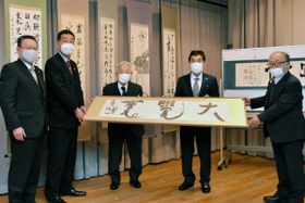 書作品を受け渡す書道団体「飛雲会」の牛丸好一会長（一番右）ら＝三木市福井、市立教育センター