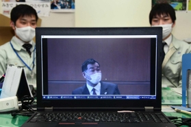 仲田一彦市長の訓示を動画で見る市職員＝三木市役所