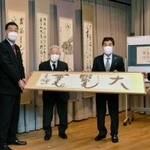 書作品を受け渡す書道団体「飛雲会」の牛丸好一会長（一番右）ら＝三木市福井、市立教育センター
