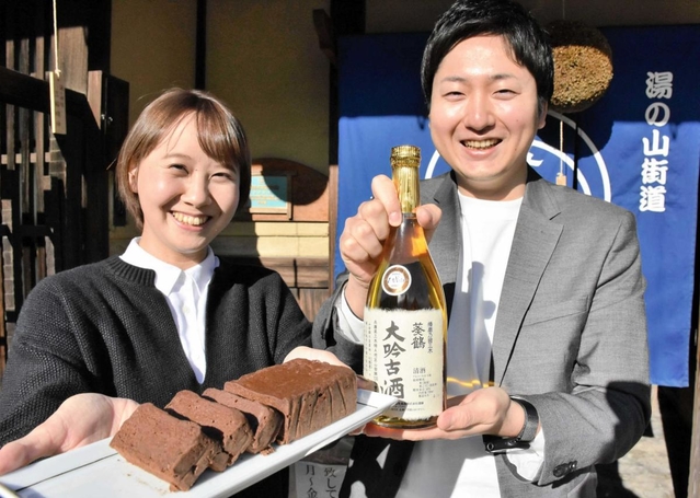 日本酒ガトーショコラを持つ魚住莉穂さん（左）と徳沢精悟さん＝三木市芝町、稲見酒造