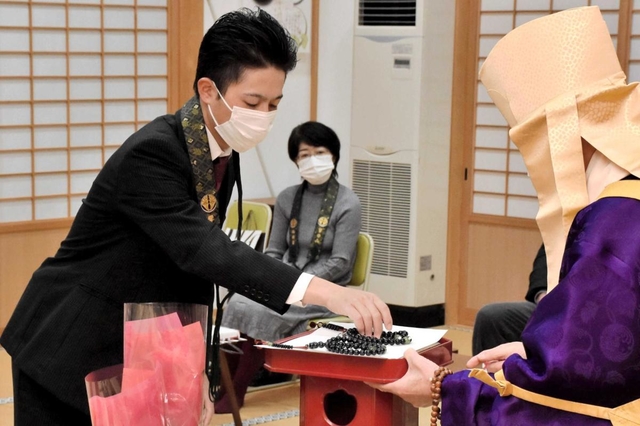 ２連の数珠を受け取る木下誠祐さん＝林鐘寺