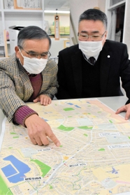 地図を見ながら計画を振り返る緑が丘町まちづくり協議会長の矢野進さん（左）と大和ハウス工業の藤岡正さん＝三木市緑が丘町東１、三木市生涯活躍のまち推進機構