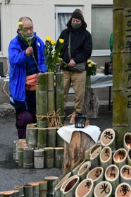 竹で作った献花台に花を手向ける参加者＝三木市志染町広野