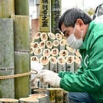 竹灯籠に明かりをともすメンバー＝三木市志染町広野