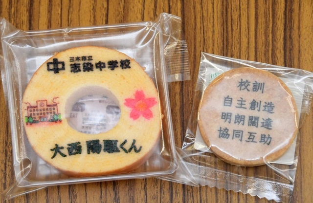 生徒の名前をあしらったバウムクーヘンと校訓を刻んだクッキー＝志染中学校