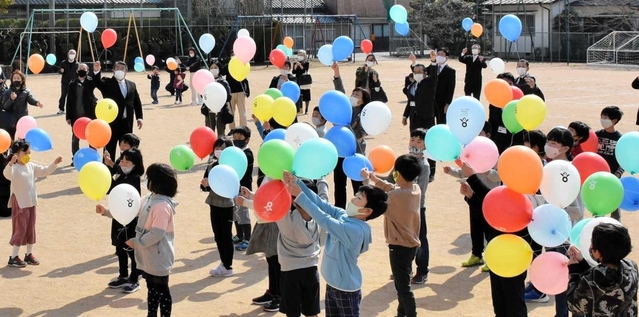 感謝の思いを込めて、風船を空へと放つ児童や保護者ら＝上吉川小学校