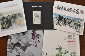 劉素真さんは、自身の画集も寄贈した＝堀光美術館