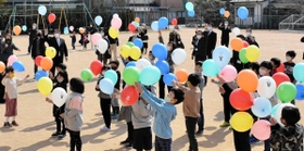 感謝の思いを込めて、風船を空へと放つ児童や保護者ら＝上吉川小学校