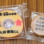 生徒の名前をあしらったバウムクーヘンと校訓を刻んだクッキー＝志染中学校