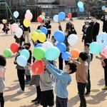 感謝の思いを込めて、風船を空へと放つ児童や保護者ら＝上吉川小学校