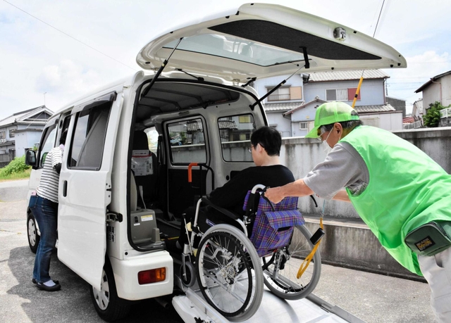 リフトカーに乗せてもらう車いす利用者＝三木市内