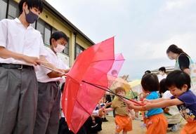 三木高生が園児に贈った「スカイアンブレラ」。色鮮やかな傘におおはしゃぎしていた＝三木市加佐
