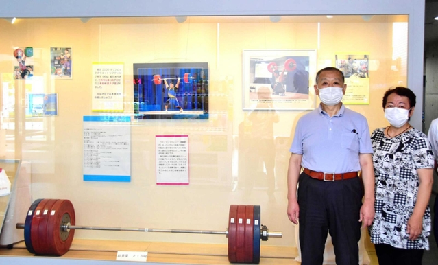 応援コーナーの展示と山本選手の母芳江さん（右）と父の英雄さん＝三木市役所