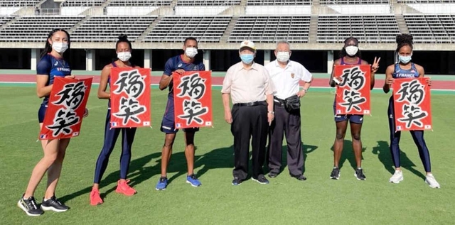 「三木凧の会」のメンバー（中央）からたこを受け取った選手ら＝県立三木総合防災公園（県教育委員会提供）