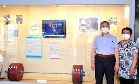 応援コーナーの展示と山本選手の母芳江さん（右）と父の英雄さん＝三木市役所