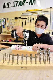竹あかりの作り方を実践するスターエムの社員＝三木市別所町東這田