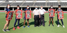 「三木凧の会」のメンバー（中央）からたこを受け取った選手ら＝県立三木総合防災公園（県教育委員会提供）