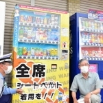 シートベルト着用を呼び掛けるラッピング自販機と設置協力者の羽田和男さん（右）＝三木市吉川町湯谷