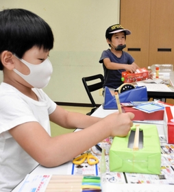 世界に一つだけの輪ゴムのギターを作る子どもたち＝青山公民館
