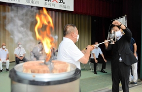聖火をランタンに移す加西市の西村和平市長（右）ら＝西脇市西脇