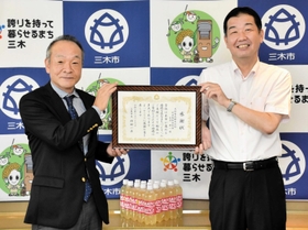 仲田一彦市長（右）から感謝状を受け取る大塚食品の田本修戦略企画部長＝三木市役所